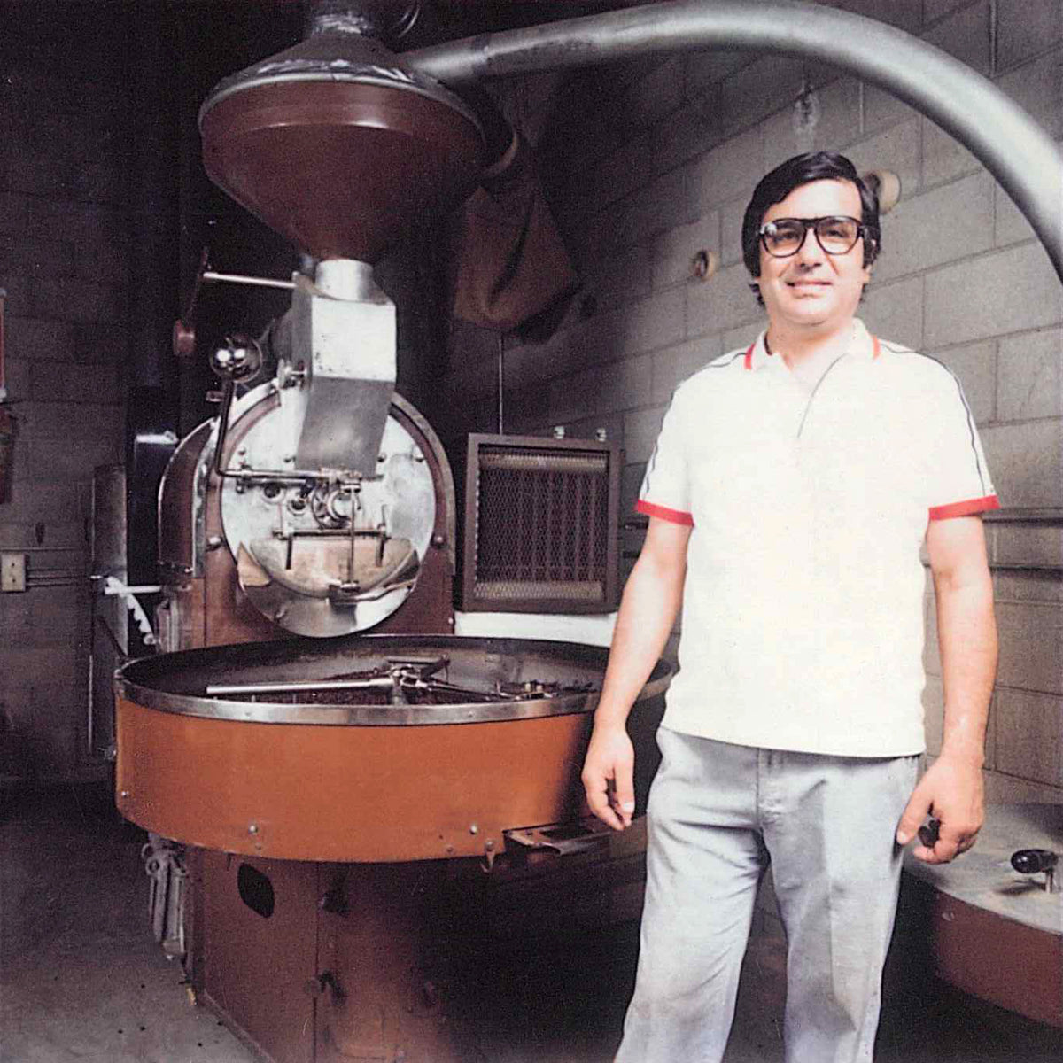 Carlo standing next to a coffee roasting machine