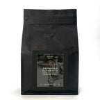 Black coffee bag with text and branding on a white background