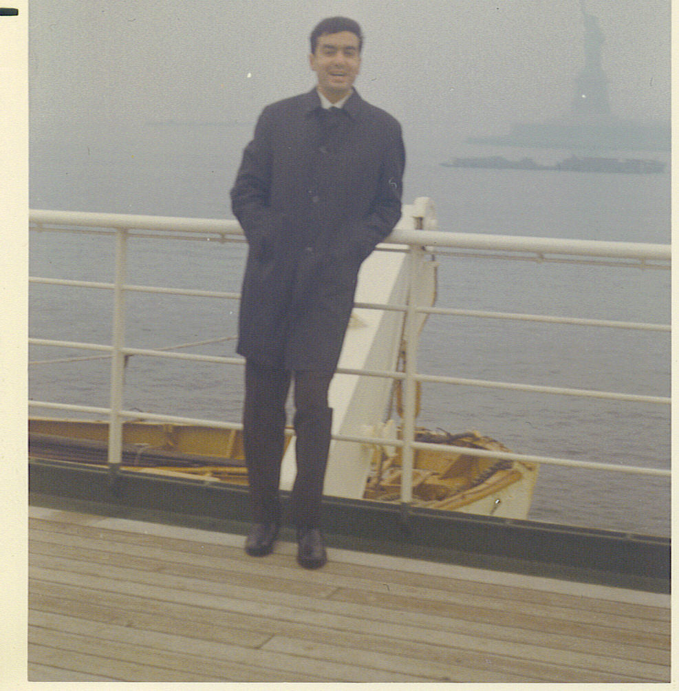 Carlo Di Ruocco on a ship deck with the Statue of Liberty in the background