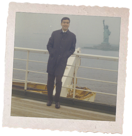 A vintage Polaroid-style photo print showing Carlo Di Ruocco as a young adult in a dark coat standing on a boat deck with the Statue of Liberty in the background.