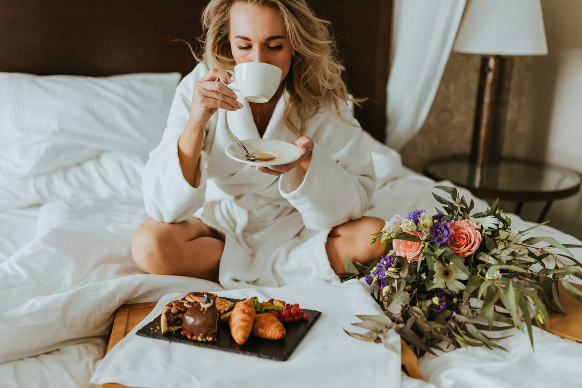 Hotel guest enjoying coffee and pastries in bed